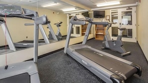 A fitness room with treadmills, a mirrored wall, and a television. - Comfort Inn Pickering (Pickering)