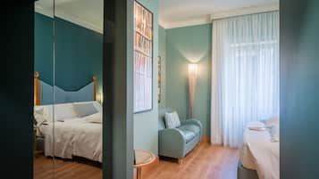 Una camera da letto moderna con un letto, un divano e uno specchio.