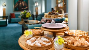 A buffet table with various pastries and a tiered dessert display in a hotel lobby. - Hotel Spadari Al Duomo (Milan)