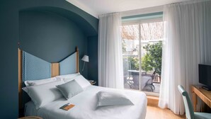 A hotel room with a bed, a desk, a chair, and a view of the outside. - Hotel Spadari Al Duomo (Milan)