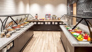 A buffet area with various food options, including fruits, vegetables, and prepared dishes.
