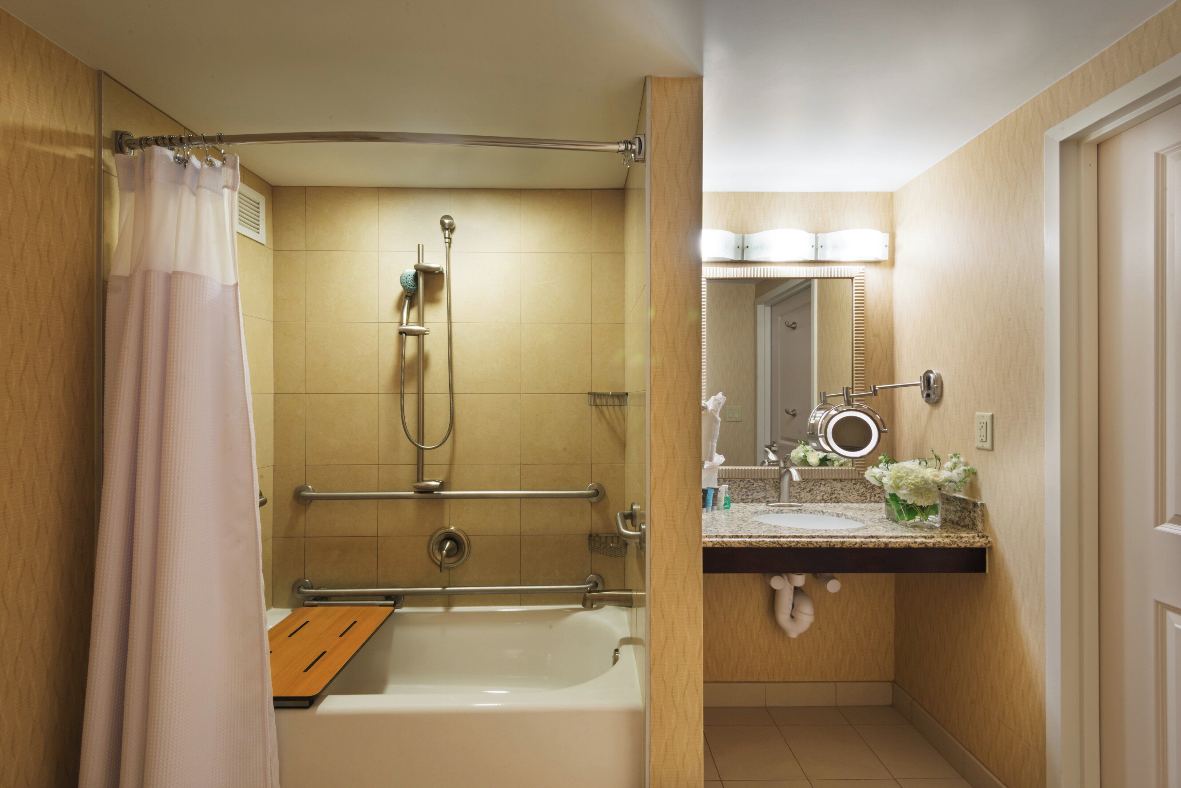 Une salle de bain avec une baignoire, une douche et un meuble-lavabo avec un miroir.