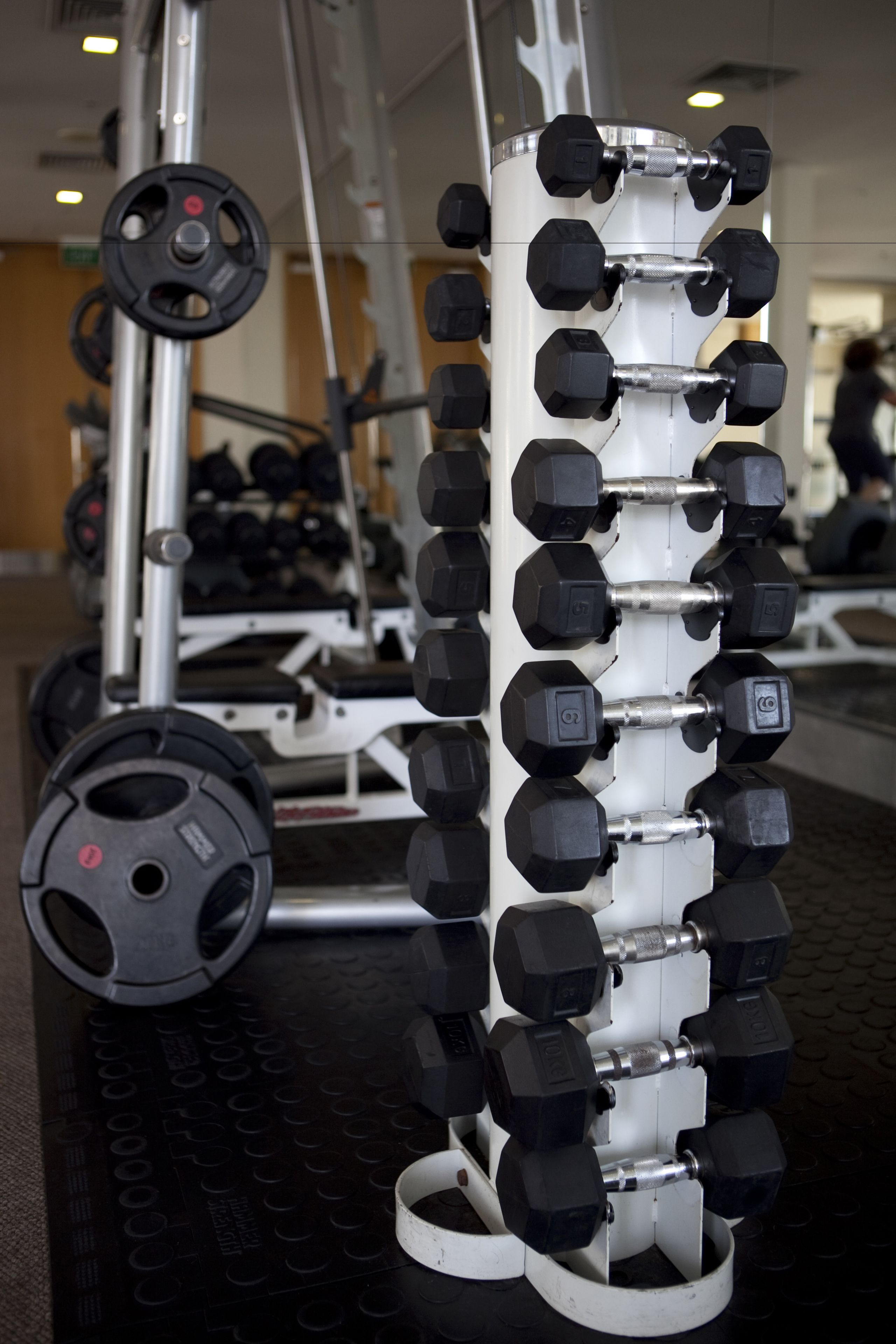 A weightlifting rack with multiple dumbbells and weight plates.