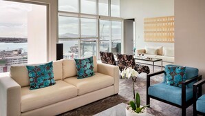 A modern living room with a large window, a sofa, a chair, and a coffee table. - Pullman Auckland Hotel & Apartments (Auckland)