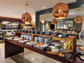 A buffet with various food options and a kitchen in the background. - Pullman Auckland Hotel & Apartments (Auckland)