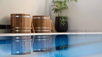 Una piscina techada, sillones reclinables de piscina