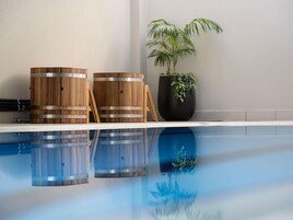Una piscina techada, sillones reclinables de piscina