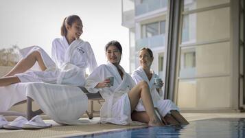 Una piscina techada, sillones reclinables de piscina