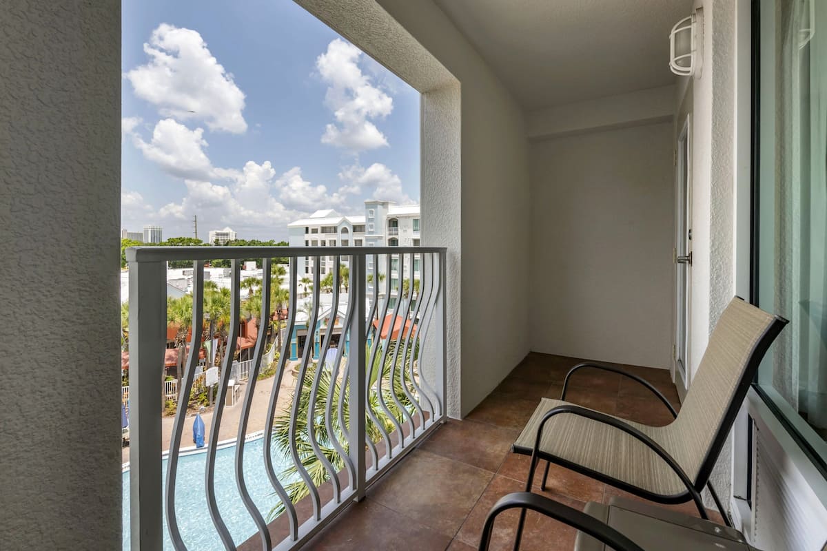 Ein Balkon mit Blick auf einen Swimmingpool und Gebäude.