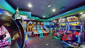 An arcade with various gaming machines, including racing and motorcycle games.