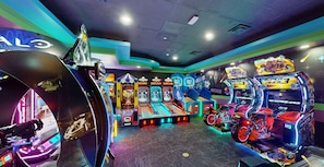Um salão de jogos com diversas máquinas, incluindo jogos de corrida e de moto.