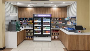 Um bar de café e área de bebidas geladas em um mercado, com painéis de madeira e disposição organizada.