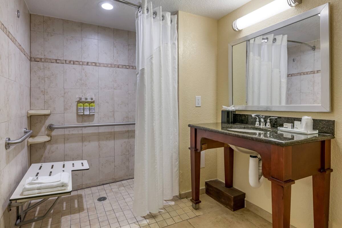 A bathroom with a shower, toilet, and sink.
