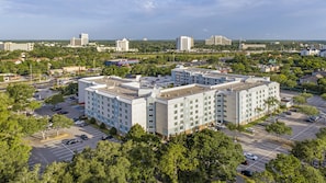 A multi-story hotel with a central courtyard, surrounded by parking and greenery. - Holiday Inn Resort Orlando - Lake Buena Vista by IHG (Orlando)