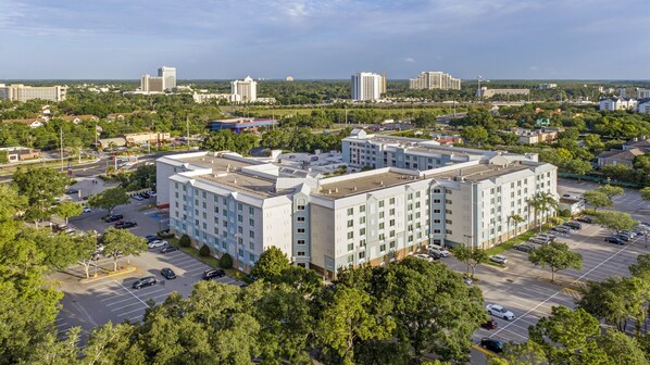 A multi-story hotel with a central courtyard, surrounded by parking and greenery. - Holiday Inn Resort Orlando - Lake Buena Vista by IHG (Orlando)