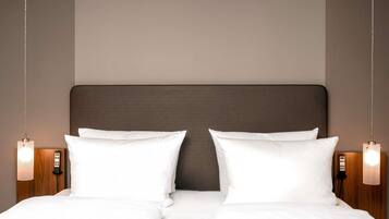 A double bed with a dark headboard, two bedside lamps, and a wooden nightstand.