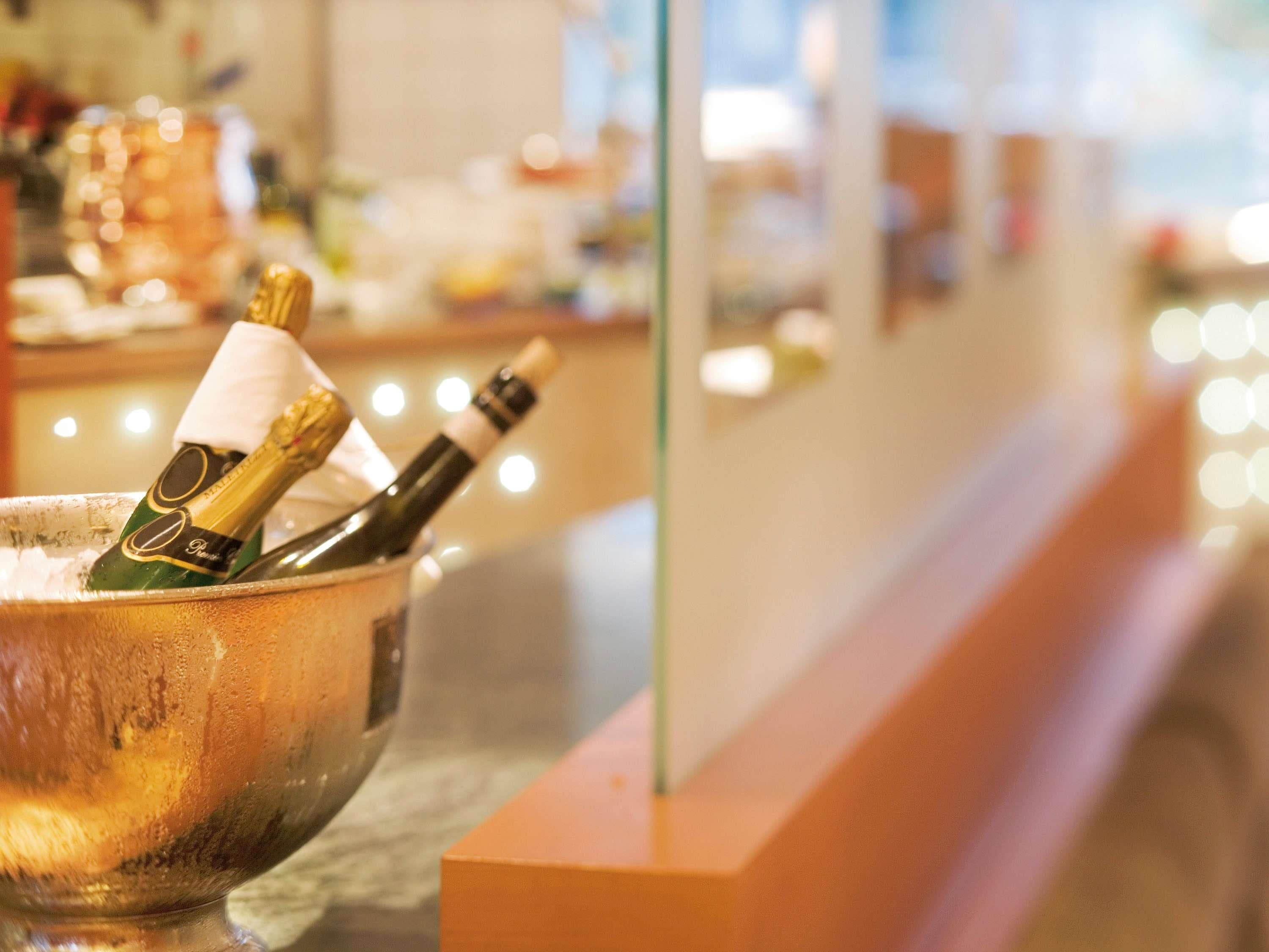 Een bar met een metalen emmer vol champagneflessen.