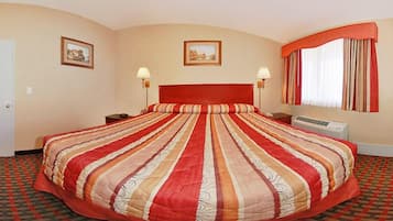 A hotel room with a large bed, two bedside tables, a window with curtains, and two wall-mounted lamps.
