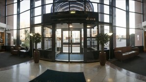 A lobby with a revolving door, seating areas, and large windows. - Copthorne Hotel Manchester Salford Quays (Salford)