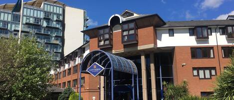 A hotel entrance with a blue canopy and a sign reading "COPTORNE."