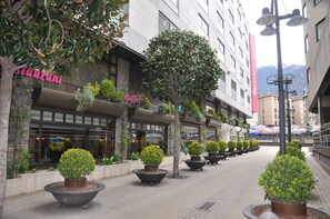 A hotel corridor with potted plants, a sign for 'Staurani', and a 'Buffer' restaurant. - Mercure Andorra (Andorra la Vella)