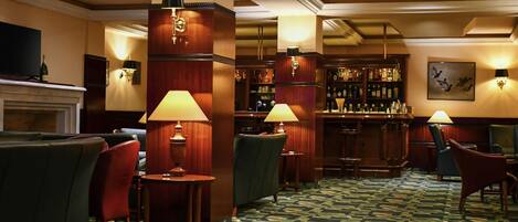 A bar area with wooden furniture, bar stools, and a patterned carpet.