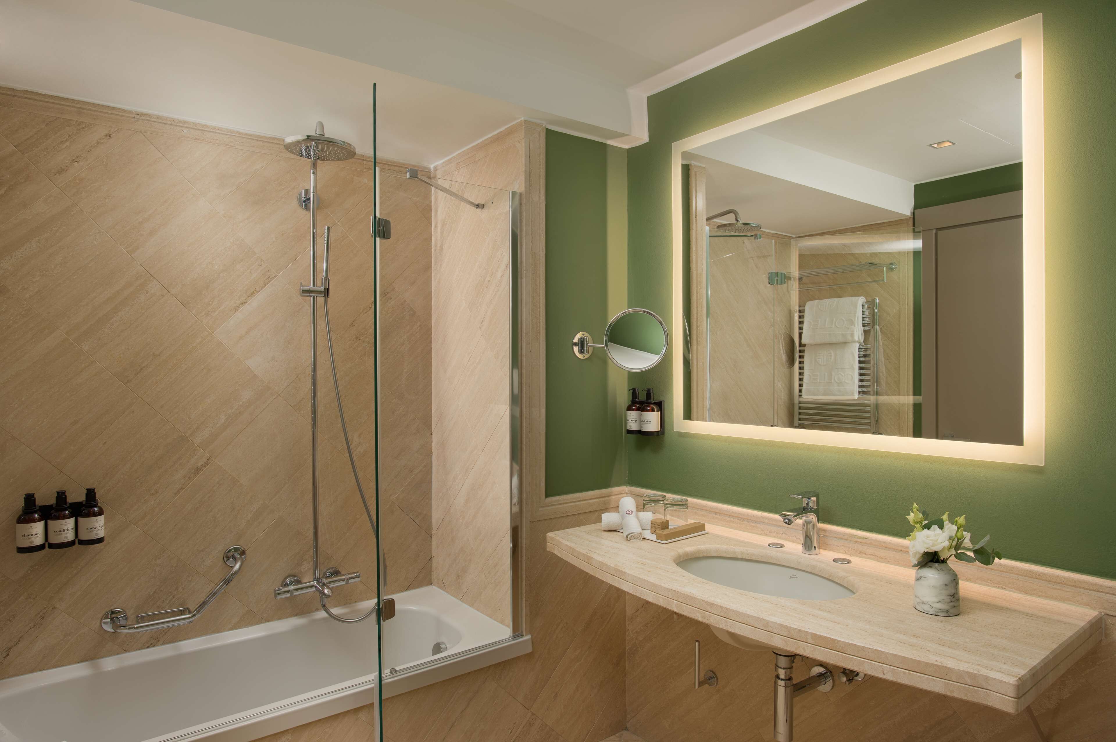 Une salle de bain moderne dotée d’une douche à parois de verre, d’un meuble-lavabo à deux vasques et d’un grand miroir.
