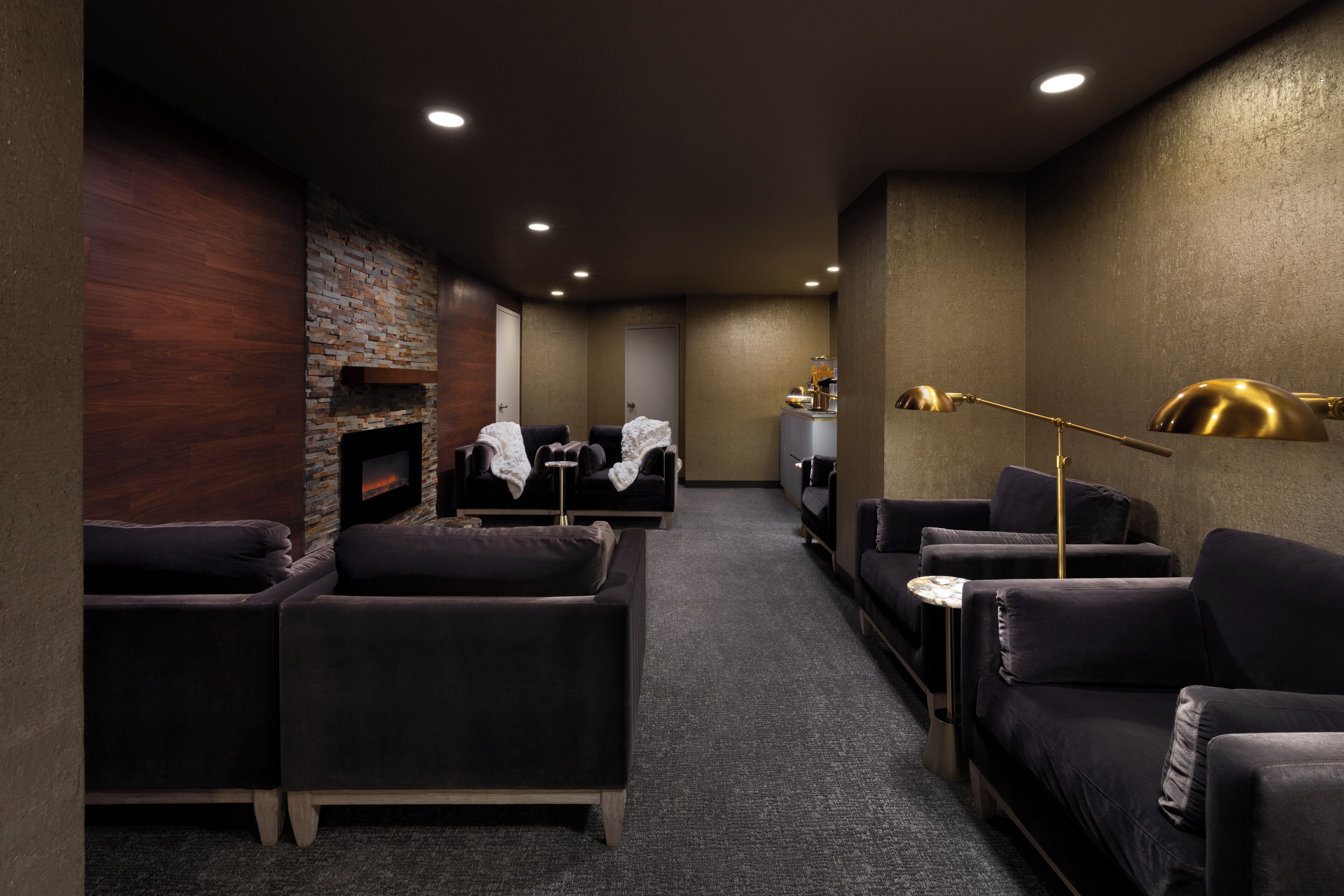 A lounge area with sofas, a fireplace, and a lamp.