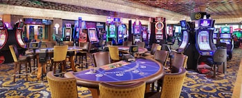 A large hotel with a curved facade, surrounded by a well-maintained lawn and a small pond. at Westgate Las Vegas Resort & Casino
