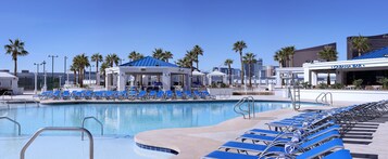 A pool area with blue lounge chairs, a gazebo, and a Cabana Bar.