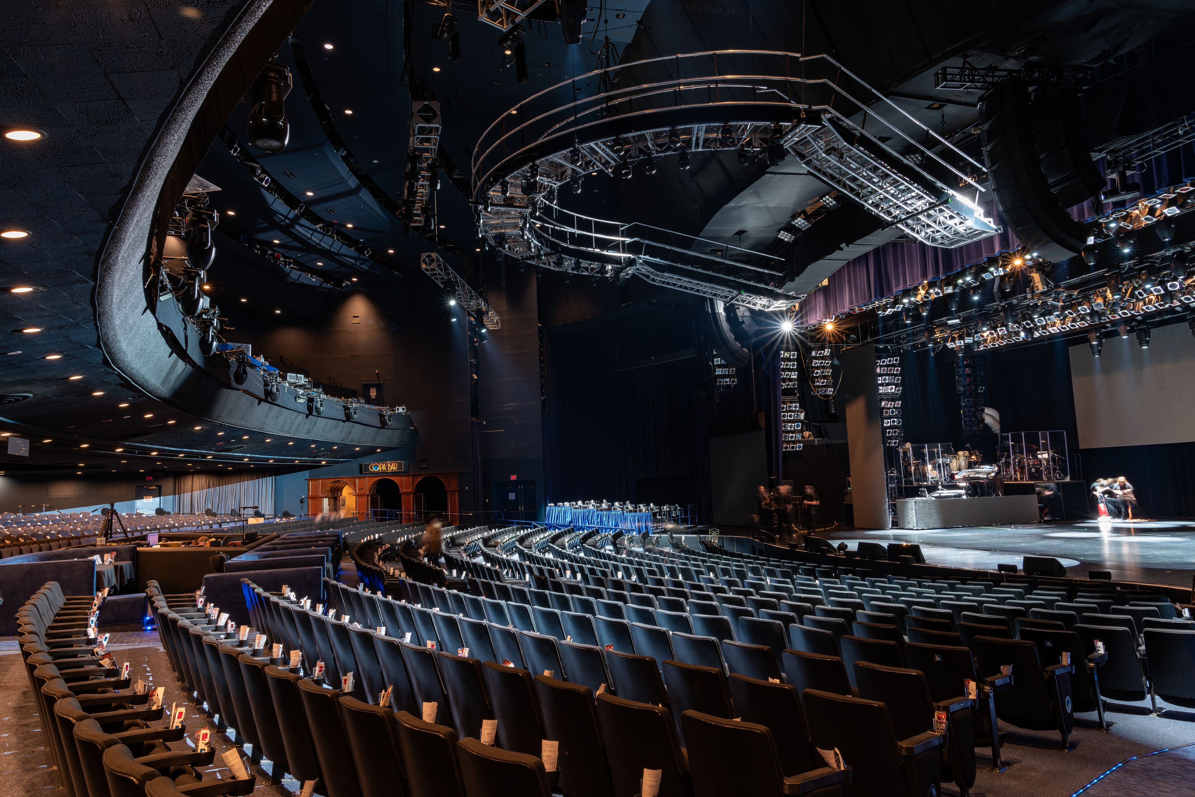 Un auditorio amplio con asientos escalonados, un escenario y una compleja instalación de iluminación.