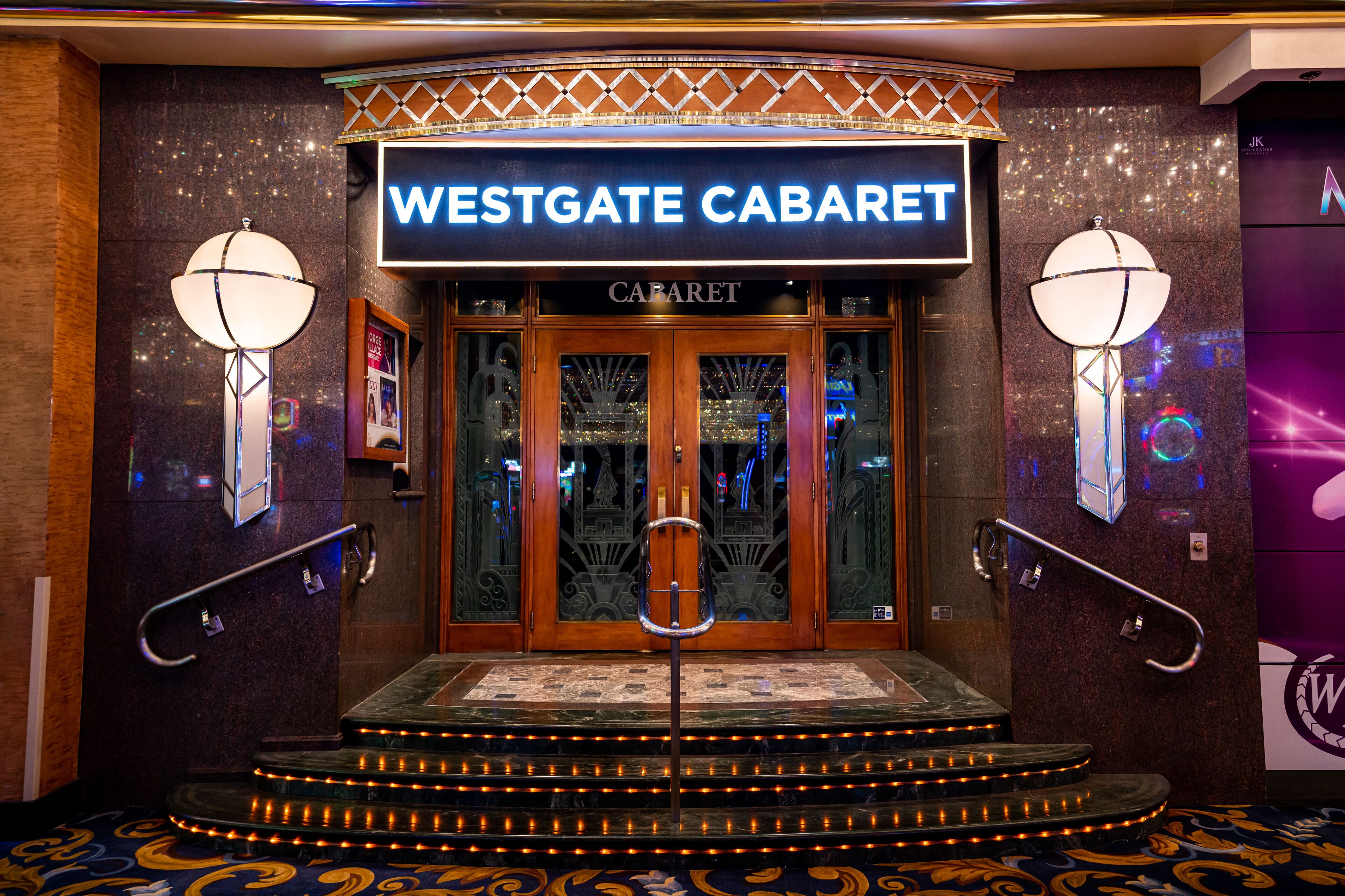 The entrance to Westgate Casino, featuring a prominent sign, a grand staircase, and decorative wall sconces.