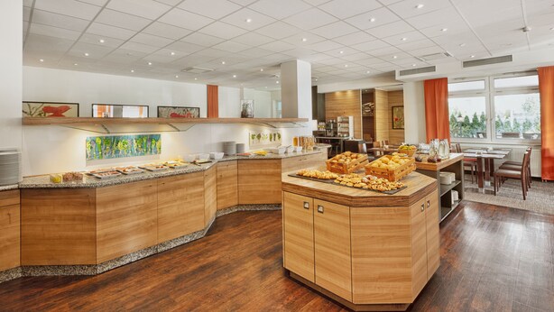 A modern kitchen with wooden cabinets, a granite countertop, and a central island with food items.