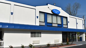A building with a sign reading "Economy Inn" and a 24-hour sign.