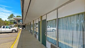 A row of motel rooms with large windows and a covered outdoor area. - Star Motel Hattiesburg University Area (Hattiesburg)