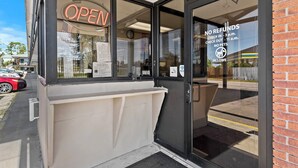 A hotel entrance with a glass door, a neon 'OPEN' sign, and a 'NO REFUNDS' policy notice. - Star Motel Hattiesburg University Area (Hattiesburg)