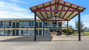 A covered outdoor area with a building in the background. - Star Motel Hattiesburg University Area (Hattiesburg)