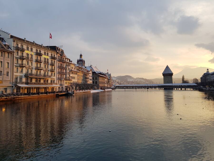 Vista del río con un hotel, un puente y una torre al fondo.