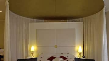 Une chambre d’hôtel avec un grand lit, deux tables de chevet avec des lampes et un plafond cintré.