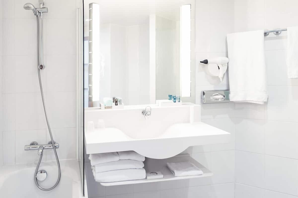 Un baño moderno con ducha, lavabo y espejo.