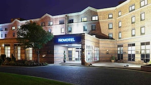 A Novotel hotel with a brick facade, large windows, and a well-lit entrance.