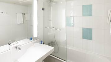 A modern bathroom with a glass-enclosed shower, a white sink with a mirror, and a bathtub.