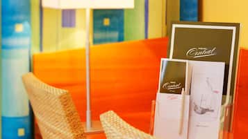 A hotel reception desk with a clear glass display case containing a welcome brochure and a pen.