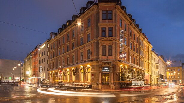 Un edificio storico con un caffè al piano terra, ampie finestre e uno stile architettonico classico.