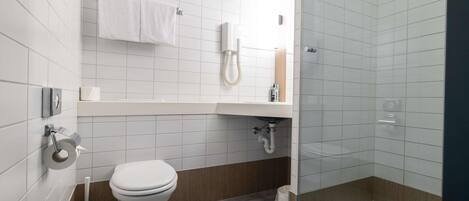 A modern bathroom with a toilet, sink, and shower.