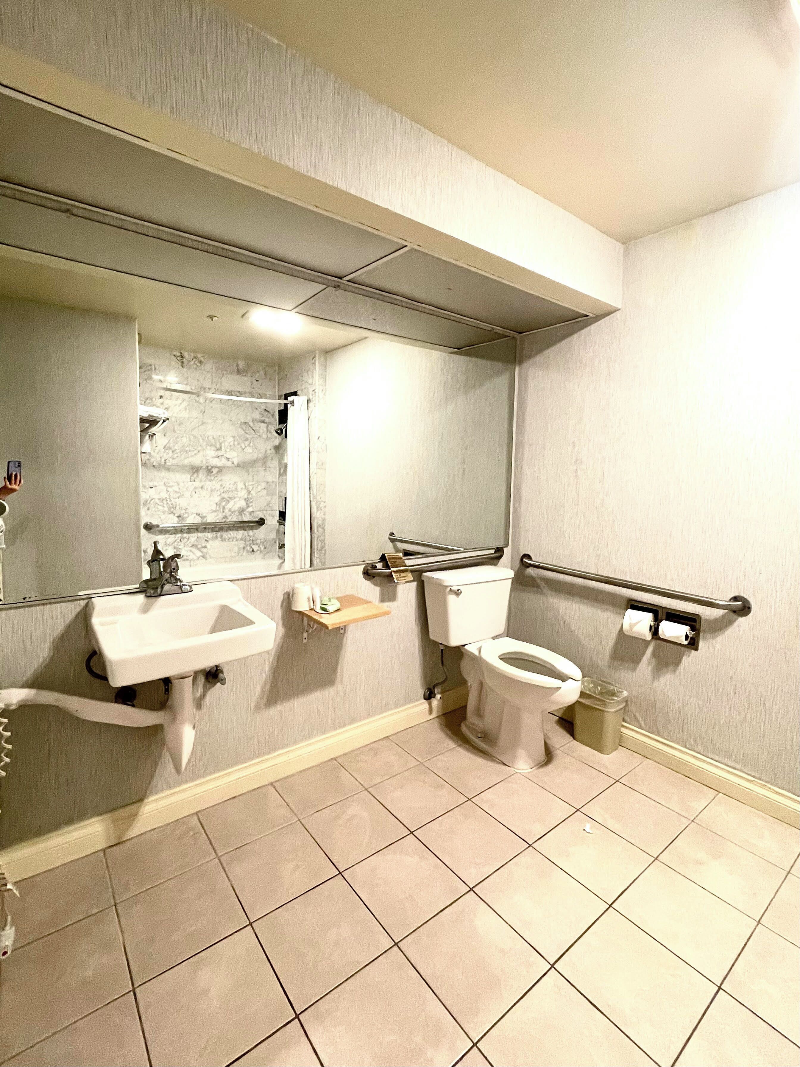 Ein Badezimmer mit Waschbecken, Toilette und Spiegel.