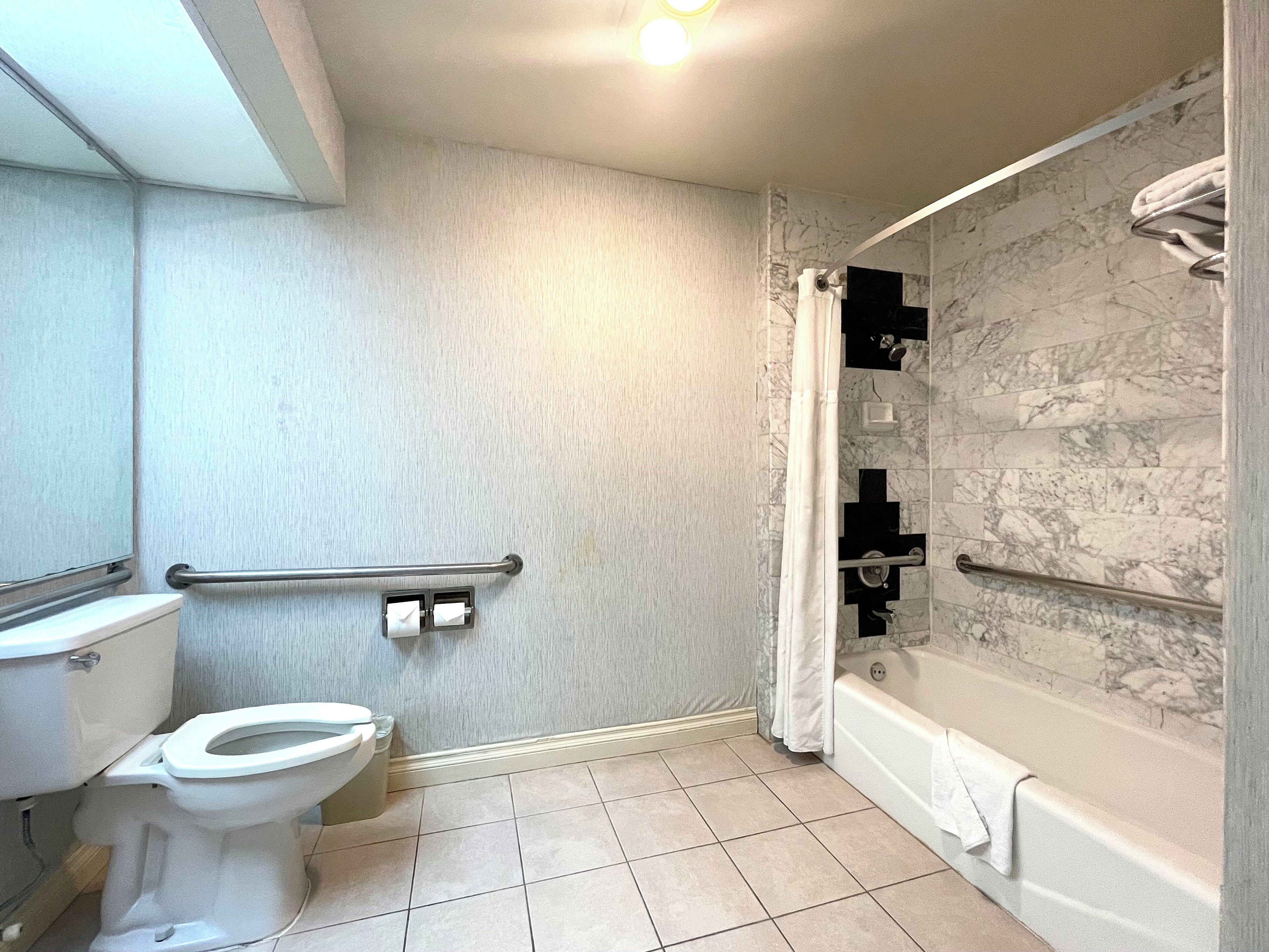 Une salle de bain comprenant des toilettes, une douche avec une porte en verre et une baignoire.