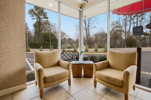 Relax in the lobby's cozy seating area, featuring two armchairs and a small table.