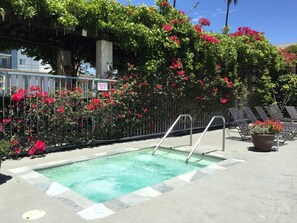 A swimming pool with a metal ladder, surrounded by a concrete deck. - Mikado Hotel - Universal Studios/Burbank (Valley Village)