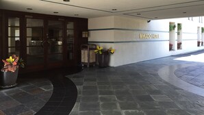 A hotel entrance with a tiled floor, a reception desk, and a wall with the hotel name. - Mikado Hotel - Universal Studios/Burbank (Valley Village)